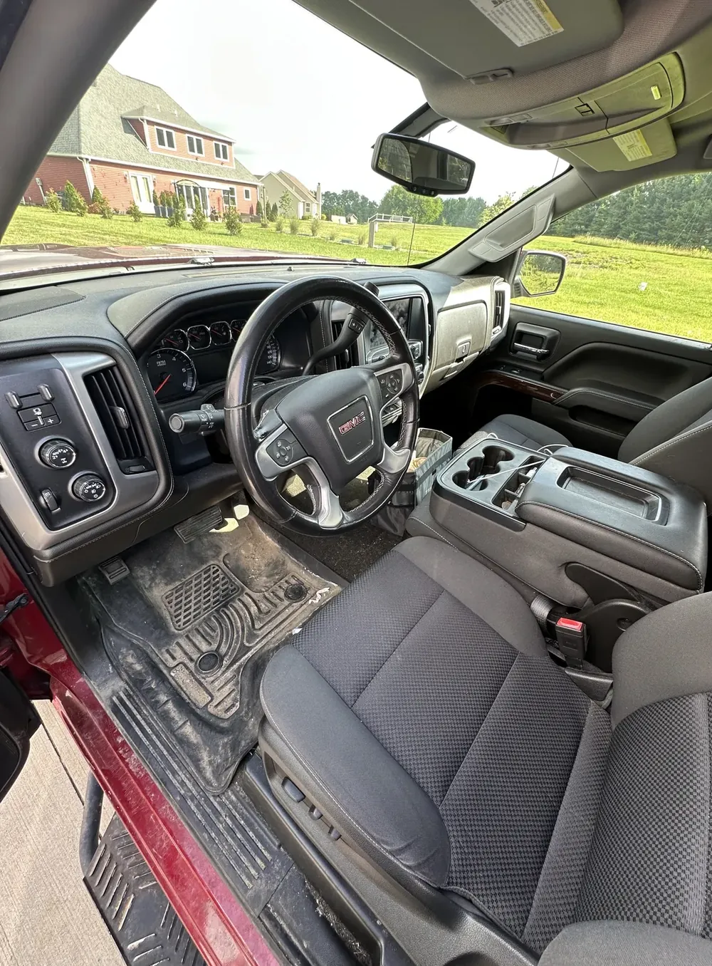 GMC Sierra front cabin before the interior detail: muddy mats and dusty dash